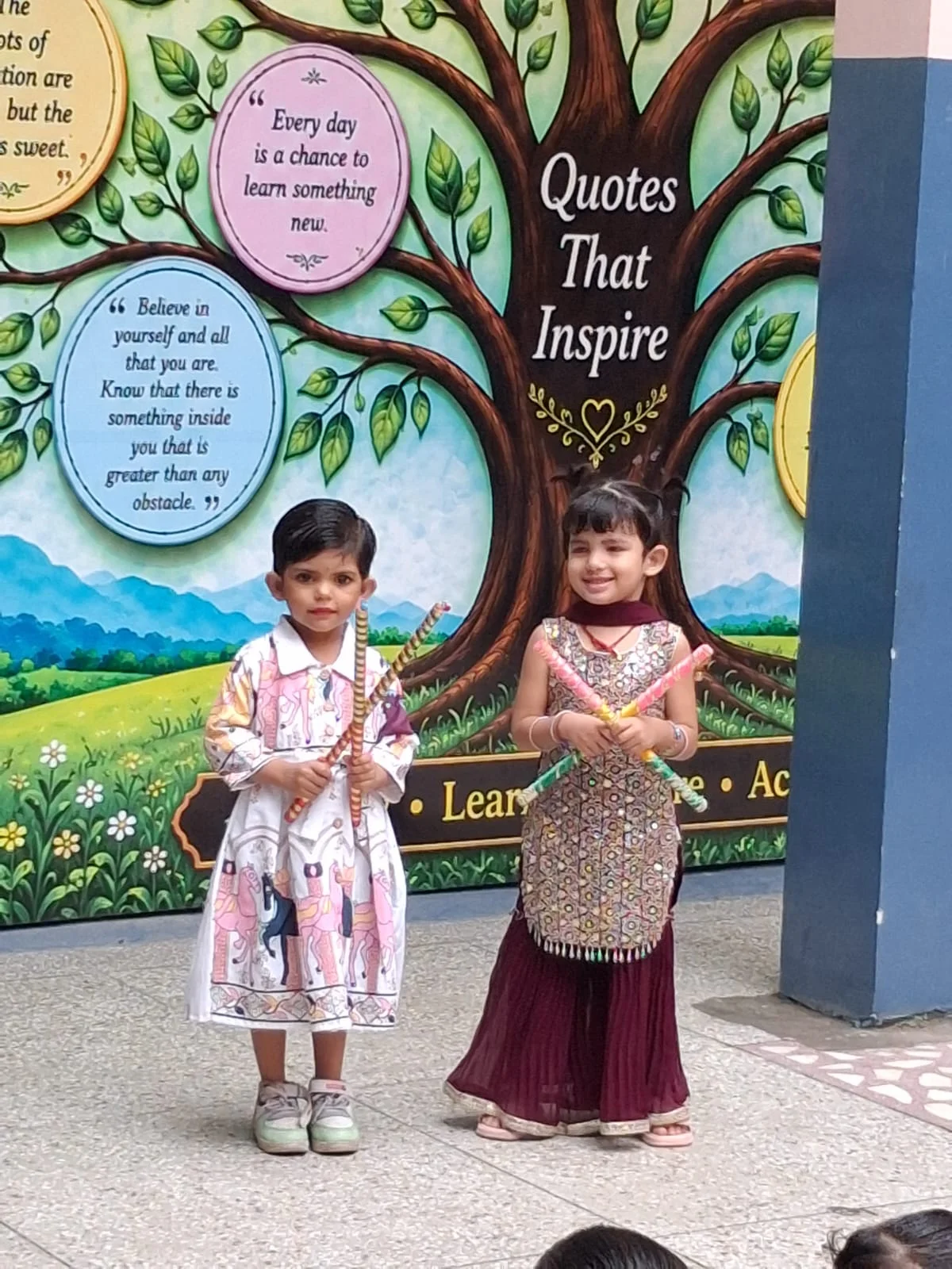 Young students in front of the Quotes That Inspire mural at school